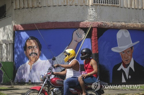 오르테가 대통령(왼쪽)과 혁명영웅 산디노의 벽화가 그려진 니카라과 마나과 거리 [AP 연합뉴스 자료사진]